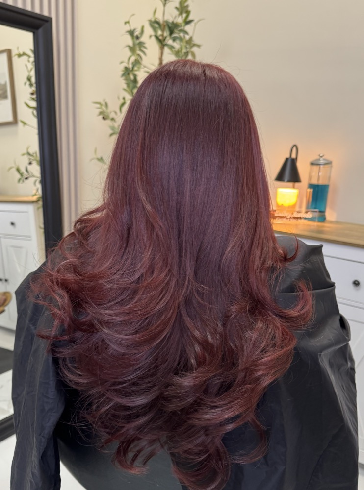 Long layered hair finished in a rich burgundy color
